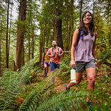 Hydro Flask 40oz Wide Mouth Water Bottle - A large water bottle with a wide mouth and black lid, held by a woman in a forest setting.