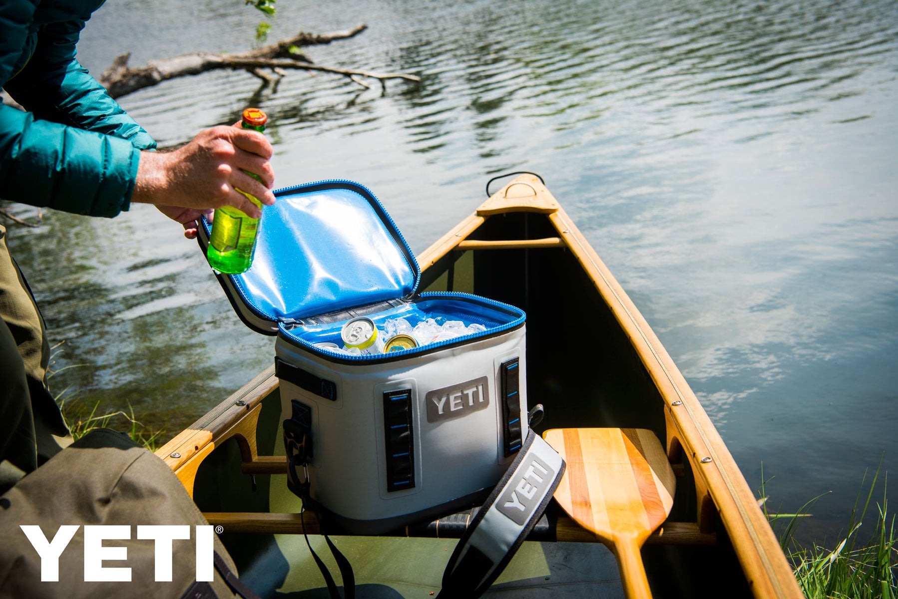 Yeti Hopper Flip 8 Personal Cooler - A white cooler with a black handle and zipper, sitting on a wooden dock by the water.