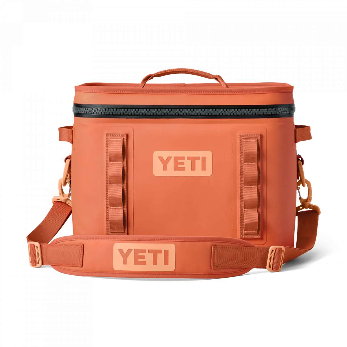 Yeti Hopper Flip 12 Personal Cooler - A coral-colored cooler with a zippered top and two side handles, featuring a textured surface and an orange logo on the front.