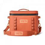 Yeti Hopper Flip 12 Personal Cooler - A coral-colored cooler with a zippered top and two side handles, featuring a textured surface and an orange logo on the front.