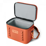 Yeti Hopper Flip 12 Personal Cooler - A coral-colored cooler with a zippered lid and two handles, featuring a rectangular shape and a small logo on the front.