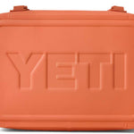 Yeti Hopper Flip 18 Personal Cooler - A coral-colored cooler with a rectangular shape and rounded corners, featuring two handles on either side.