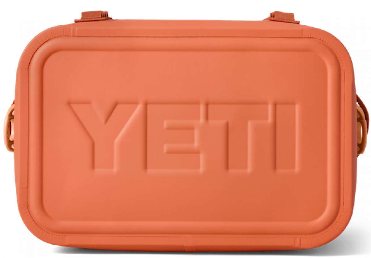 Yeti Hopper Flip 18 Personal Cooler - A coral-colored cooler with a rectangular shape and rounded corners, featuring two handles on either side.