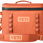 Yeti Hopper Flip 18 Personal Cooler - A coral-colored cooler with a zippered top and two side handles, featuring a textured surface and an embossed logo on one side.