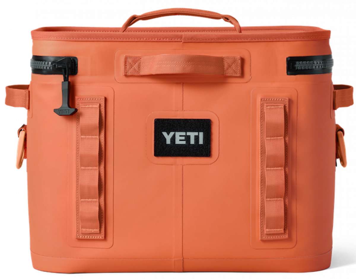 Yeti Hopper Flip 18 Personal Cooler - A coral-colored cooler with a handle on top and an orange zipper pull.