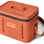 Yeti Hopper Flip 18 Personal Cooler - A coral-colored cooler with a zippered lid and two handles on top, featuring a rectangular shape and a flat bottom.