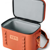 Yeti Hopper Flip 18 Personal Cooler - A red cooler with a handle and zipper closure on top, featuring an orange logo that reads "YETI" in bold letters.