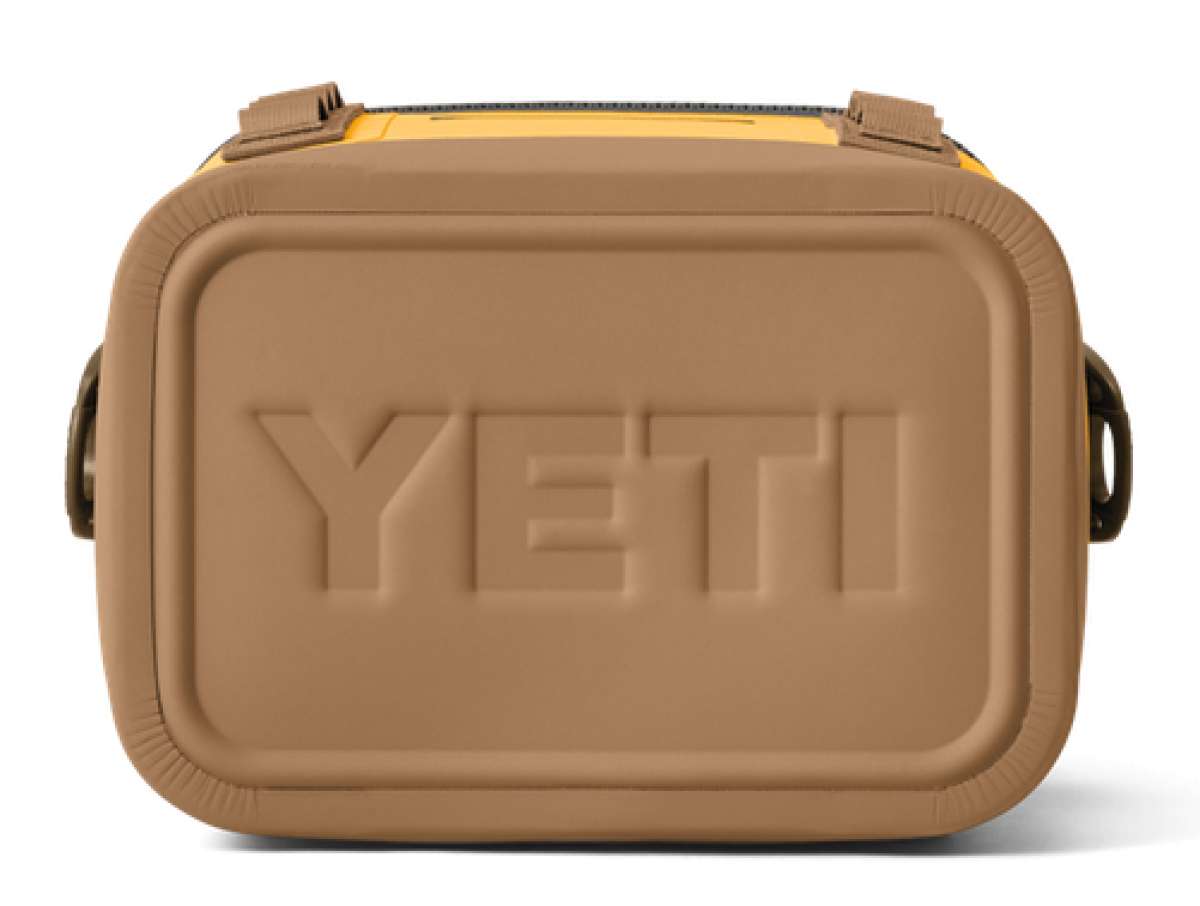 Yeti Hopper Flip 8 Personal Cooler - A tan cooler with a zippered lid and two handles on either side, featuring a prominent "YETI" logo embossed in the center of the front panel.