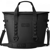 Yeti Hopper M30 2.0 Soft Cooler - A black cooler with a handle and shoulder strap, featuring a zippered top and two side pockets.
