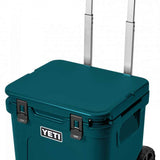 Yeti Roadie 48 Wheeled Cooler - A compact, wheeled cooler with a dark gray lid and handle, featuring a small white logo on the front that reads "YETI" in bold letters.