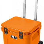 Yeti Roadie 48 Wheeled Cooler - A wheeled cooler with a handle on top and wheels at the bottom, featuring a large logo on the front that says "YETI" in white letters.