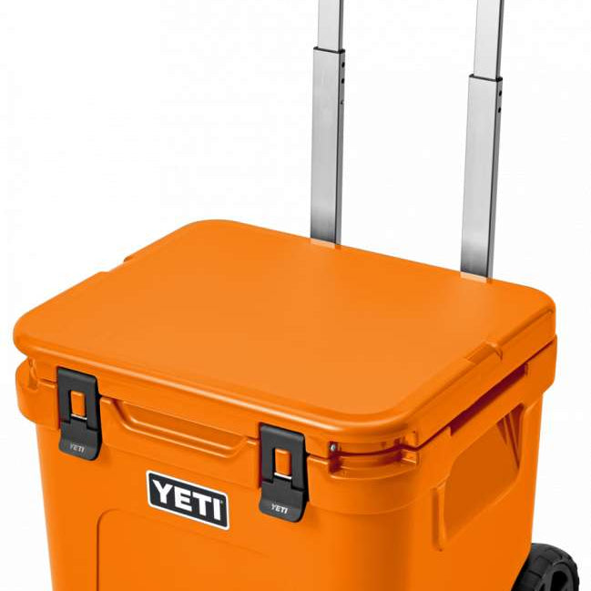 Yeti Roadie 48 Wheeled Cooler - A wheeled cooler with a handle on top and wheels at the bottom, featuring a large logo on the front that says "YETI" in white letters.