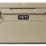Yeti Tundra 65 Cooler - A large, tan cooler with a black handle on top and two latches on either side of it.